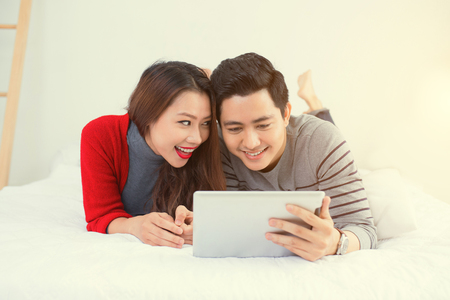 Asian young couple using digitla tablet at homeの写真素材