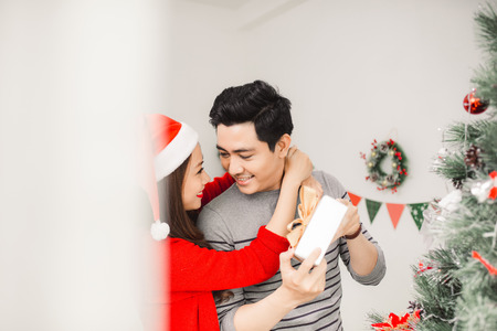 Christmas Asian Couple. Happy Smiling Family at home celebrating. New Year Peopleの写真素材
