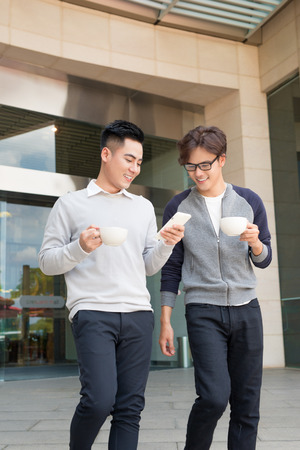 Two smiling businessmen walking and talking in the cityの写真素材