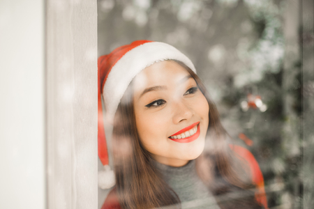 Happy young asian woman  near christmas tree celebrating New Yearの写真素材