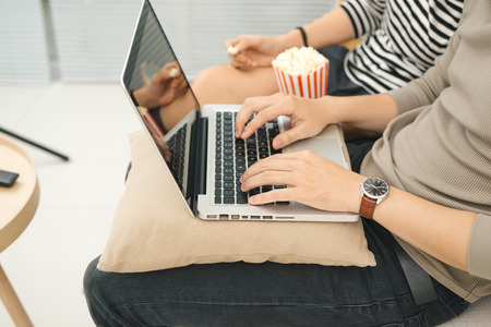 Young asian couple payment online using laptop buying movie ticket