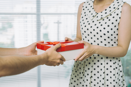 Man hand giving red gift to womanの写真素材