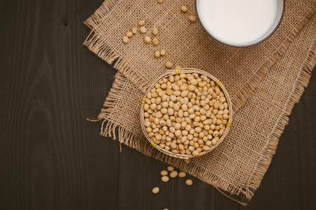 Glass with soy milk and soy bean on wooden backgroundの写真素材