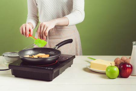 House wife wearing apron making. Steps of making cooking apple cake. Cutting green apple.の写真素材