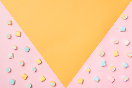 Top view of the pastel marshmallows on a pink and yellow background. Minimal style.の写真素材