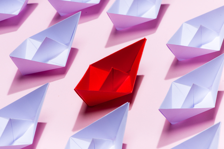 Leadership concept. Red paper ship leading among whiteの写真素材