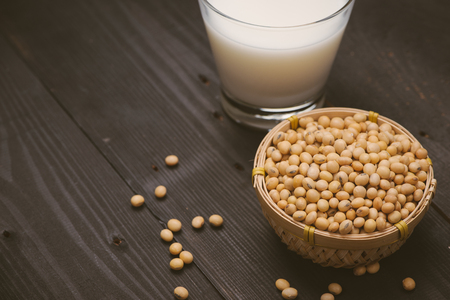 Glass with soy milk and soy bean on wooden backgroundの写真素材