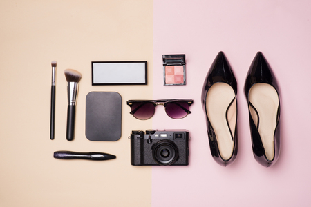 A collection of make up cosmetic beauty with camera and shoes on light color backgroundの写真素材