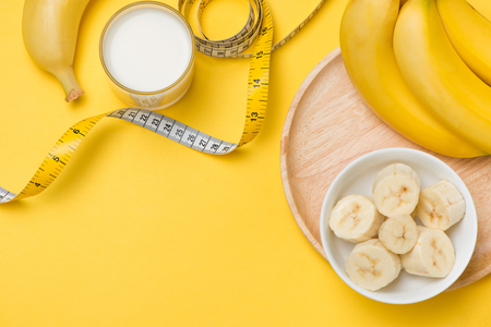 Healthy lifestyle concept - banana smoothie, measuring tapeの写真素材