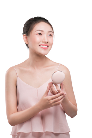 Attractive asian woman holding make-up powder product on white backgroundの写真素材