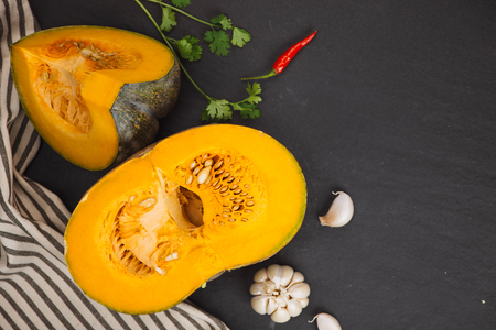 Cut Pieces of Pumpkin with seeds in Wooden Plate on the Wooden Board.Harvest,Fresh Vegetable, Ingredient.White Food Background.Top Viewの写真素材