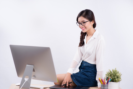 Beautiful graphic designer using graphics tablet to do her work at deskの写真素材
