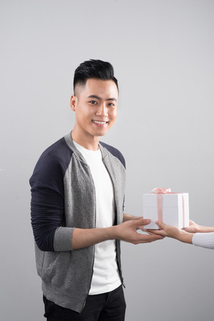 Happy smiling couple in love standing over gray background.の写真素材