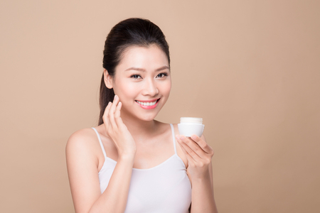 Skincare. Beautiful asian woman show moisturizer or lotion product.の写真素材