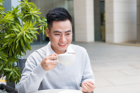 Young man sitting in a cafe on a coffee break.の写真素材
