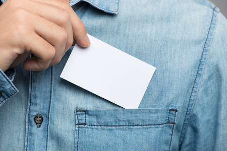 Young man who takes out blank business card from the pocket of his shirtの写真素材