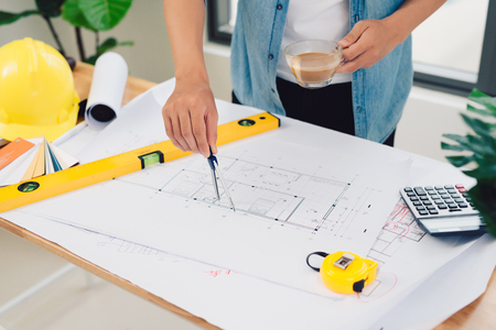 architect working and sketching architectural drawing plan on table in officeの写真素材