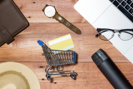 Credit card, watch, smartphone and coffee cup on wooden tableの写真素材