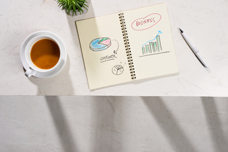 Minimal styled flat lay table with open notebook, croissant and tea.の写真素材
