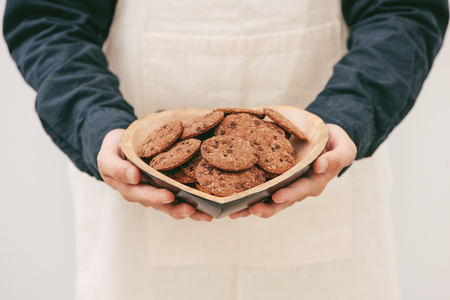 Homemade chocolate cookies on plate in male hands.の写真素材