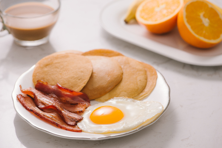 Breakfast plate with pancakes, eggs, bacon and fruit.の写真素材