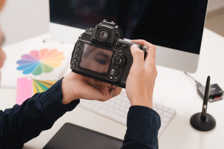 Photographer working at desk in modern officeの写真素材