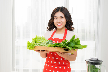 Healthy lifestyle. Happy smiling on kitchen home with green vegetables cookingの写真素材