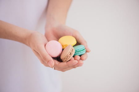 Sweet dessert. Colorful macarons on female hands.の写真素材