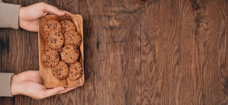 Delicious chocolate chip cookies on a plate on dark old wooden tableの写真素材