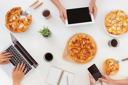 Lunch and people concept. Happy business team eating pizza in officeの写真素材