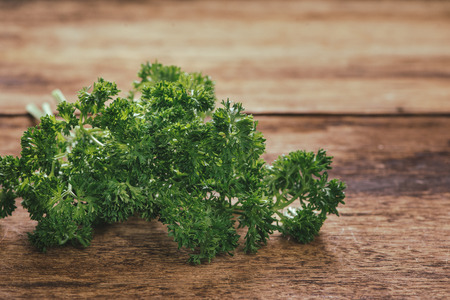 tied fresh parsley on wooden surface