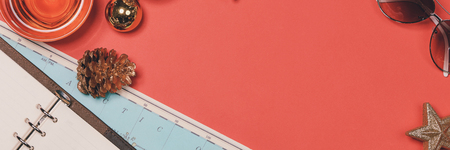 HOLIDAY travel concept - passport, camera, hat, airplane, chrismas decorations on red background....
