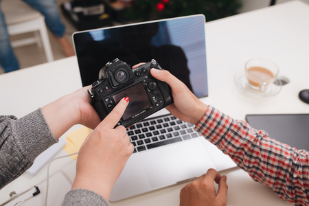 Photo editors looking at camera in studio sitting on the deskの写真素材