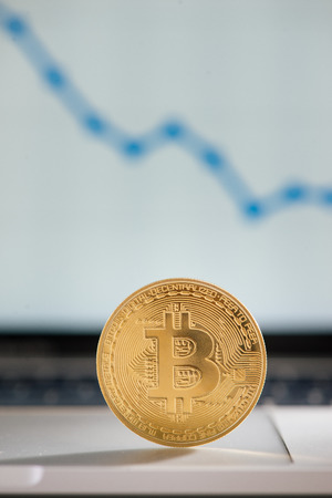 golden bitcoin on notebook keyboard with increasing chartの写真素材
