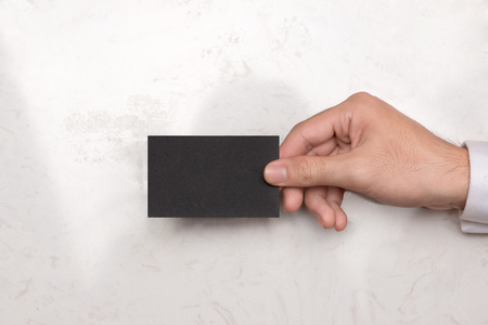Mockup of black business cards in man's handの写真素材