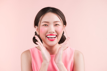 Beauty portrait of female asian face over pink color background. Studio shot.の写真素材