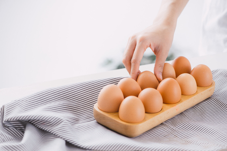 Raw chicken eggs in egg box on table.の写真素材