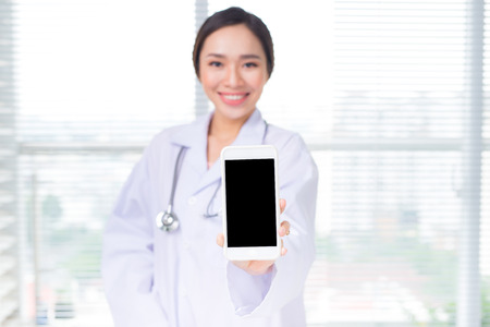 Asian woman doctor showing a smartphone screenの写真素材