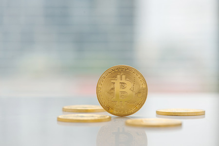 Digital currency physical gold bitcoin coin on the table near windowの写真素材