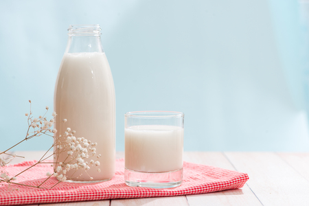 Dairy products. Bottle with milk and glass of milk on wooden tableの写真素材