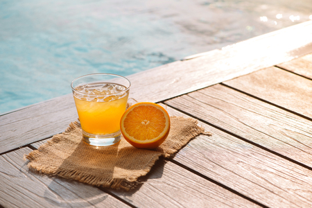 Close up of screwdriver cocktail alcohol drink with orange juice, slices and ice standing near the...