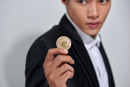 Golden Bitcoin in a man handの写真素材