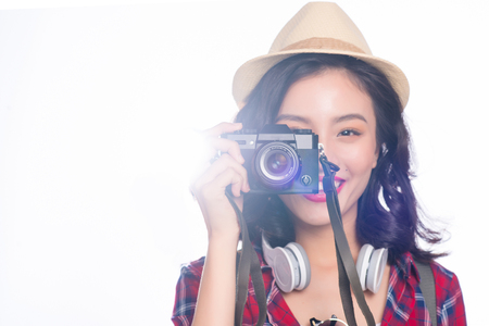 Woman travel. Young beautiful asian woman traveler taking pictures on white backgroundの写真素材