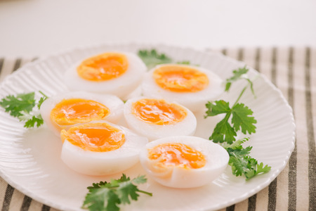 Close up medium soft boiled duck egg portion on white dishの写真素材