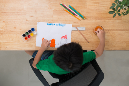 Small boy draws at the table. Top viewの写真素材