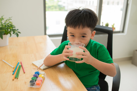 School child doing homework and drinking milkの写真素材