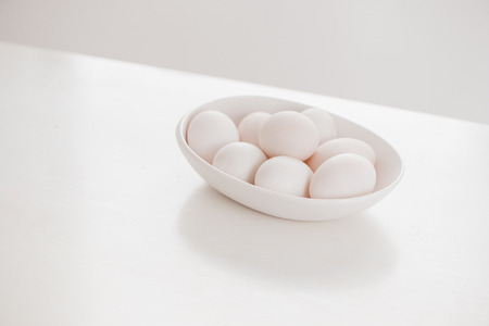 Eggs on white plate on wooden tableの写真素材
