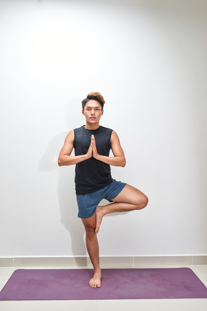 Fitness man plank workout training at white background indoors. Young guy makes exercise. Healthy lifestyle, gymnastics conceptの写真素材