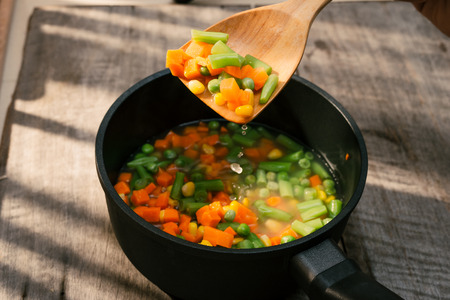 Fresh vegetable soup with sausage on wood. Whole background.の写真素材