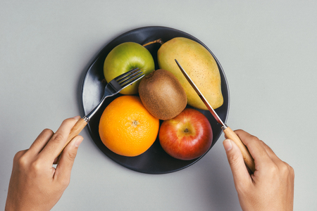 Wooden plate with fruits, and focused on kiwi. Kiwi is good for digestion, and a very healthy fruit.の写真素材